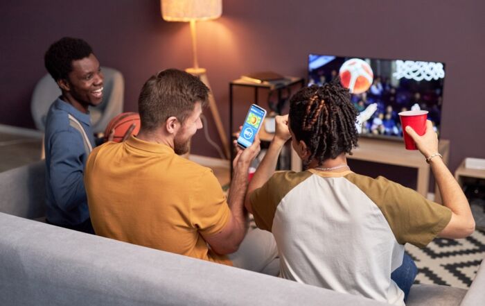 group of young men watching sports and sports betting